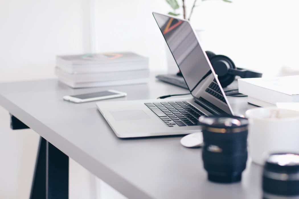 Half-closed laptop on a desk.