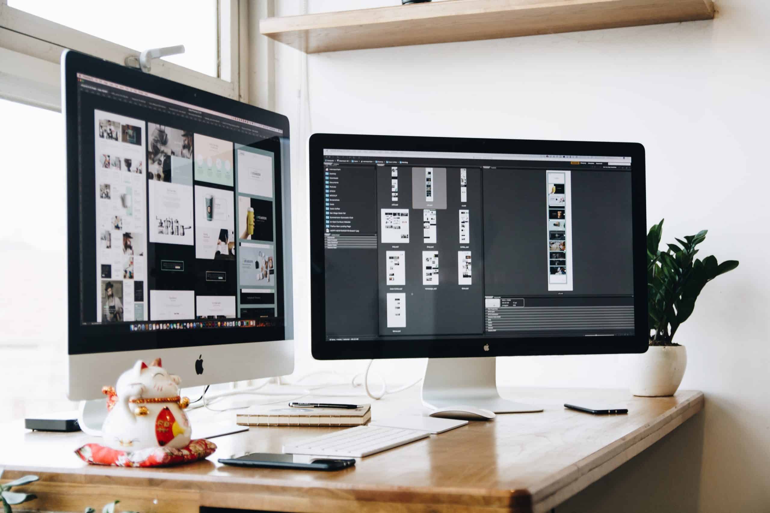 Two iMac screens on a desk, one displaying pictures and another image editing software in use.