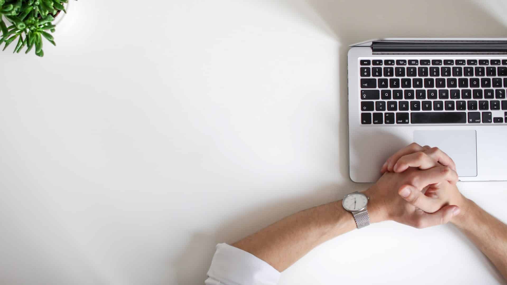 A person sits in front of their computer, waiting for a web page to load.