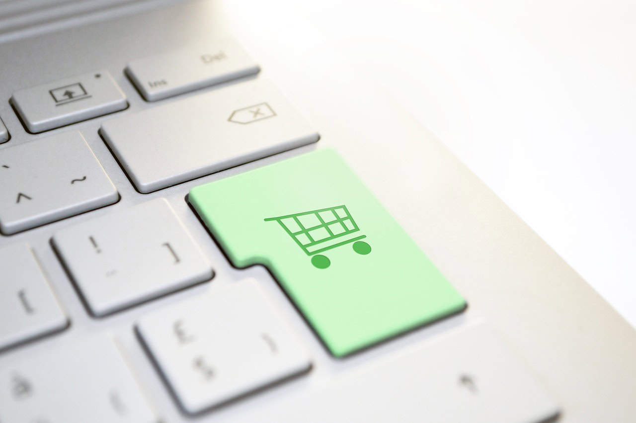 A green button with a shopping cart on a computer keyboard.