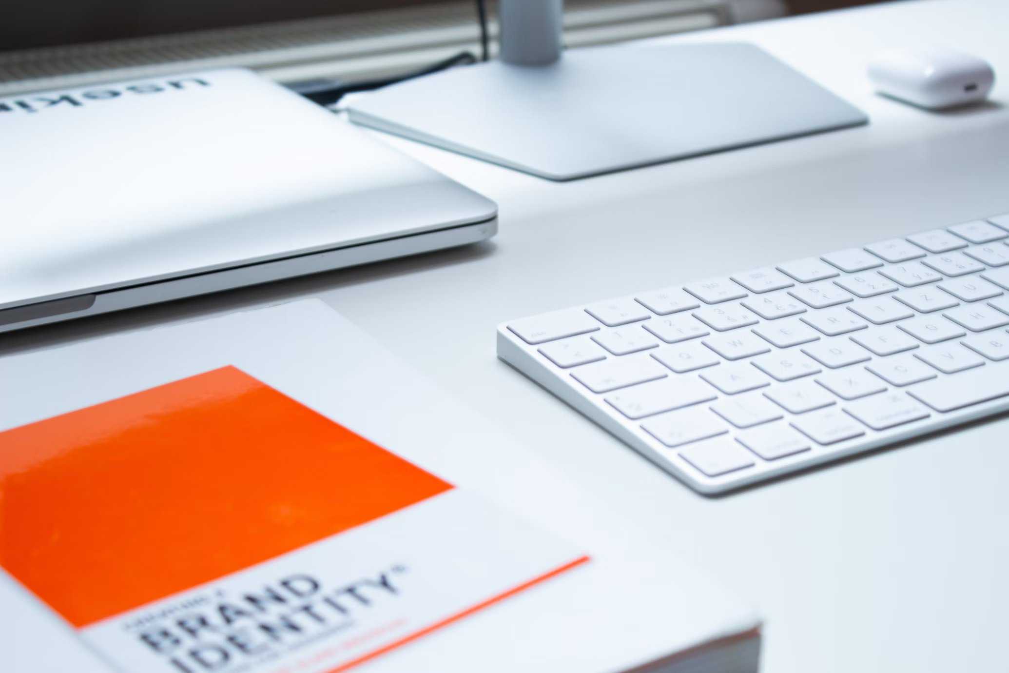 A book on brand identity and branding integration next to a silver computer.