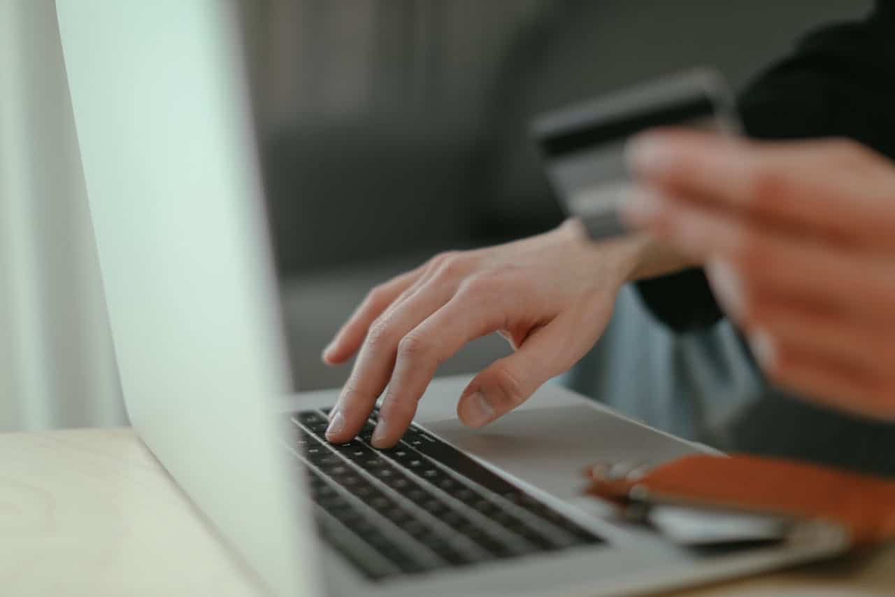 How Localization in Web Design Affects Global Marketing (2) A person holding a credit card and typing on a laptop
