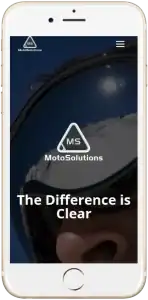 A smartphone displays the MotoSolutions website, showing a close-up of a person wearing goggles with the text The Difference is Clear and the MotoSolutions logo above it.