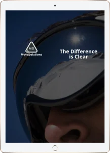 A close-up of a person wearing reflective ski goggles, showing a snowy mountain landscape in the reflection. The text reads MotoSolutions and The Difference is Clear.